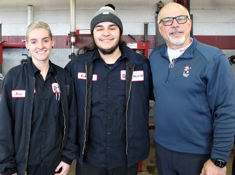 Winners of the Golden Tire Iron competition, Nina and Matt, stand with their regional director, Scott Clayton, after changing a set of four tires in eight minutes and 48 seconds.