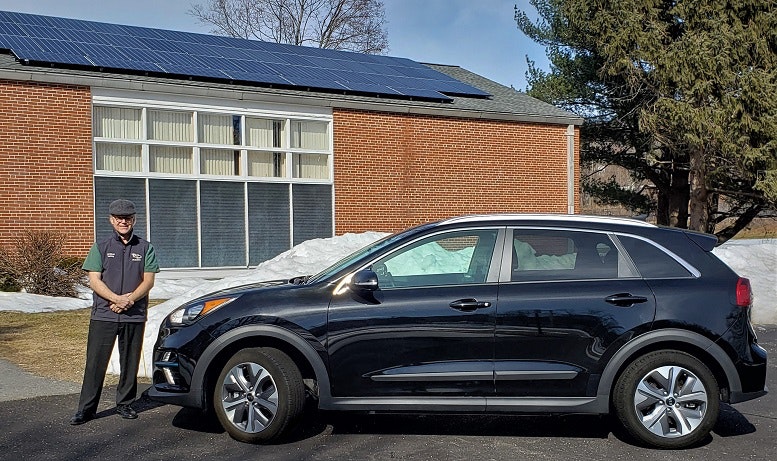 Craig Van Batenburg is pictured next to a Kia Niro EV, one piece of the electric and hybrid fleet at his training business, Automotive Career Development Center (ACDC.)