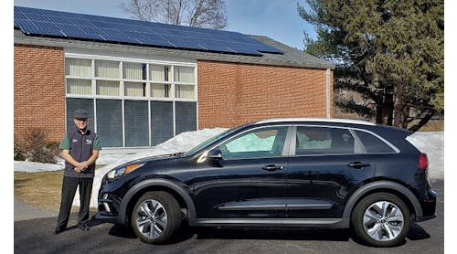 Craig Van Batenburg is pictured next to a Kia Niro EV, one piece of the electric and hybrid fleet at his training business, Automotive Career Development Center (ACDC.)