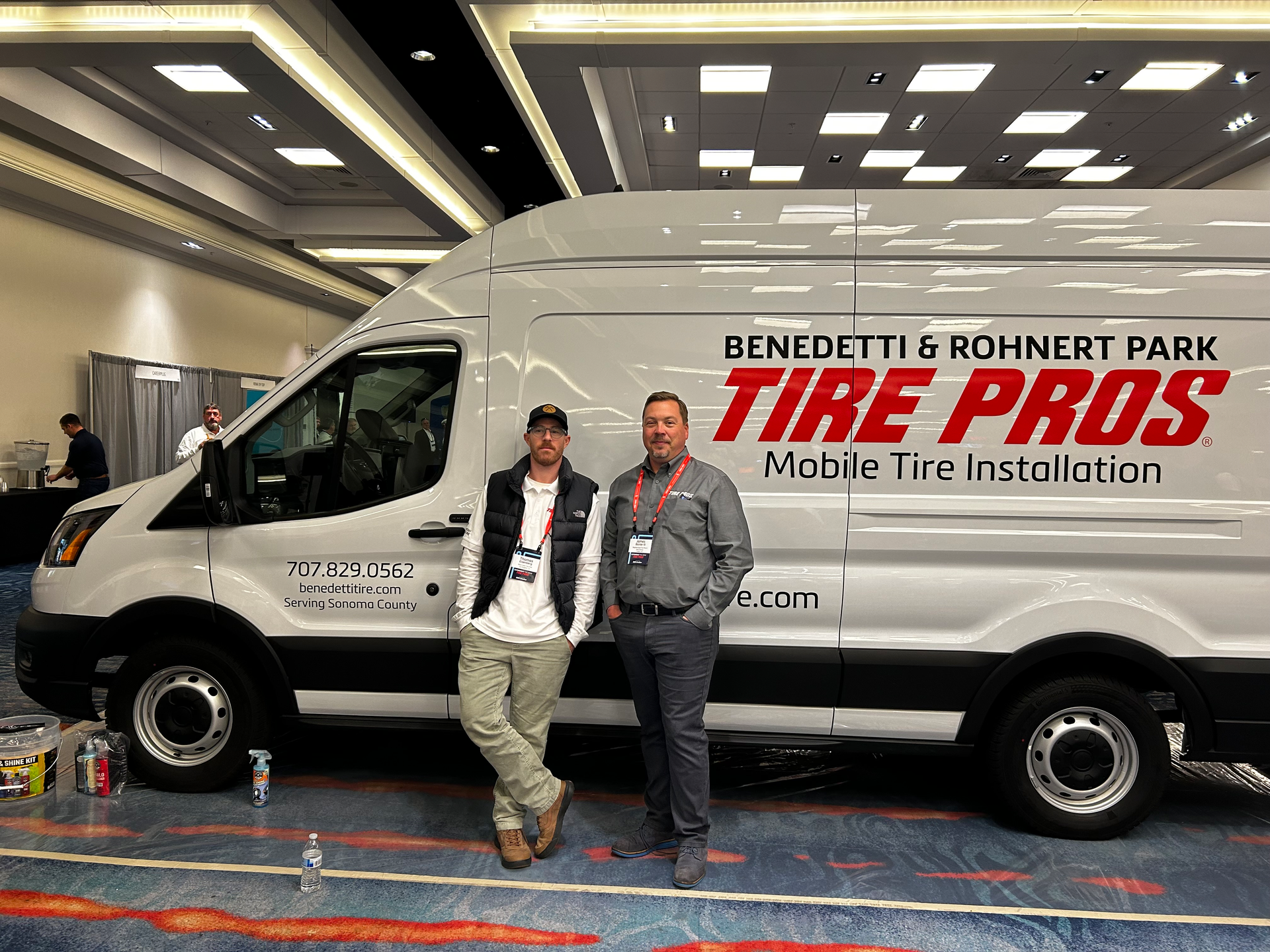 Tom Eisenberg, (L) owner of West Coast Tire and Service in Los Angeles, Calif., and James Baxter (R) owner of Atlanta, Ga.-based Neighborhood Tire Pros & Service pose with Tire Pros mobile van at the 2023 Tire Pros conference.