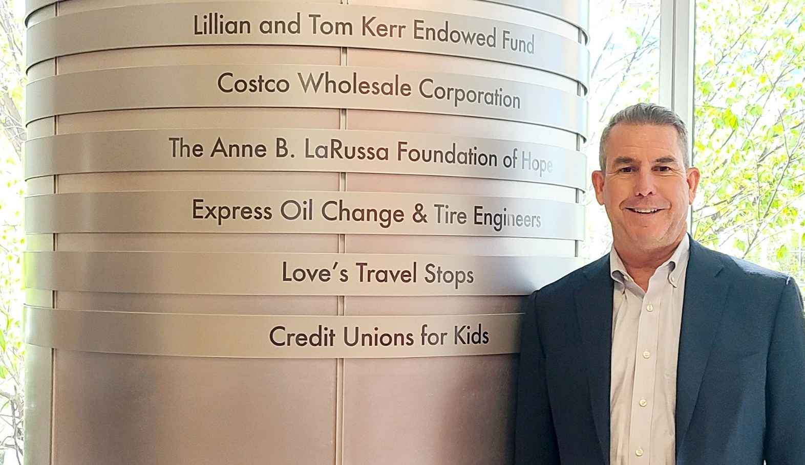 Jim Durkin, CEO of Express Oil Change & Tire Engineers, stands beside the pillar at Children's of Alabama hospital that bears the company's name for its longtime support.