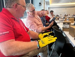 Proper equipment is a big piece of the safety puzzle for tire dealers. Jim Lanham, left, safety manager at McCarthy Tire Service, and Tim Hoekzema, risk manager for TravelCenters of America, test out gloves from Myers Tire Supply.
