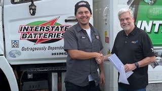 Interstate Batteries&rsquo; Stefan Gonzalez (left), who recently lost his home in a fire, receives a check from Joel Ayres, executive director of the Automotive Aftermarket Charitable Foundation.
