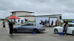 Jim Fleckner, AOT director of product development (far left) points toward Ryan Moylan of Zurcher Tire, getting out of a car, during the recent event. Jim Fleckner, AOT director of product development (far left) points toward Ryan Moylan of Zurcher Tire, getting out of a car, during the recent event.