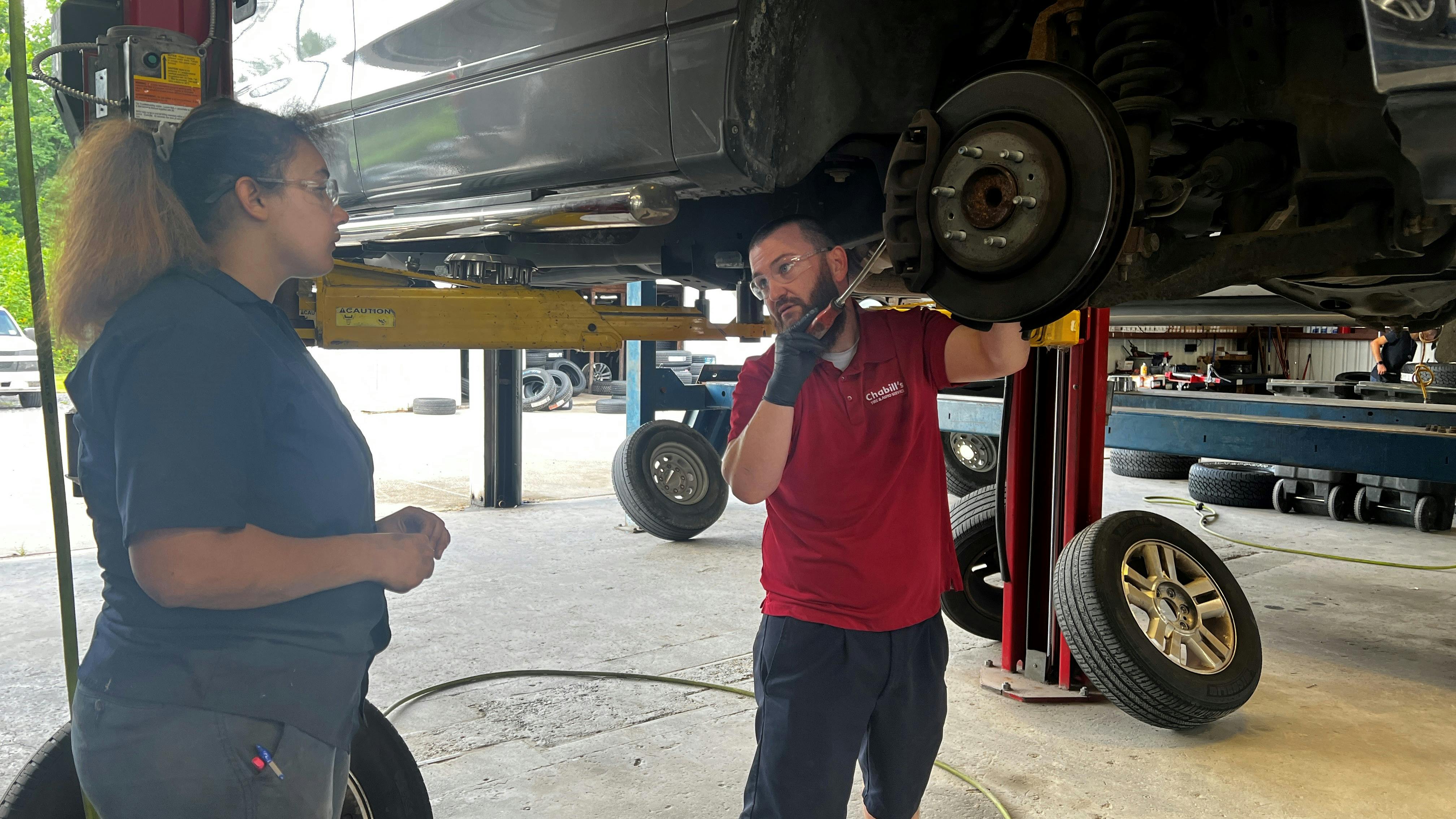Manager Russ Disalvo talks through a brake service job with Anastasia Dukes, a general service technician at Chabill's Tire & Auto Service. The tire dealership has noticed a trend that its young managers experience less turnover among their youngest staff members.