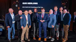 Gus Herlong of Palmetto Garage Works in Columbia, S.C. - joined here by his employees and Ralph Luberda, Midas vice president - was named Midas Franchisee of the Year in the multi-unit category.