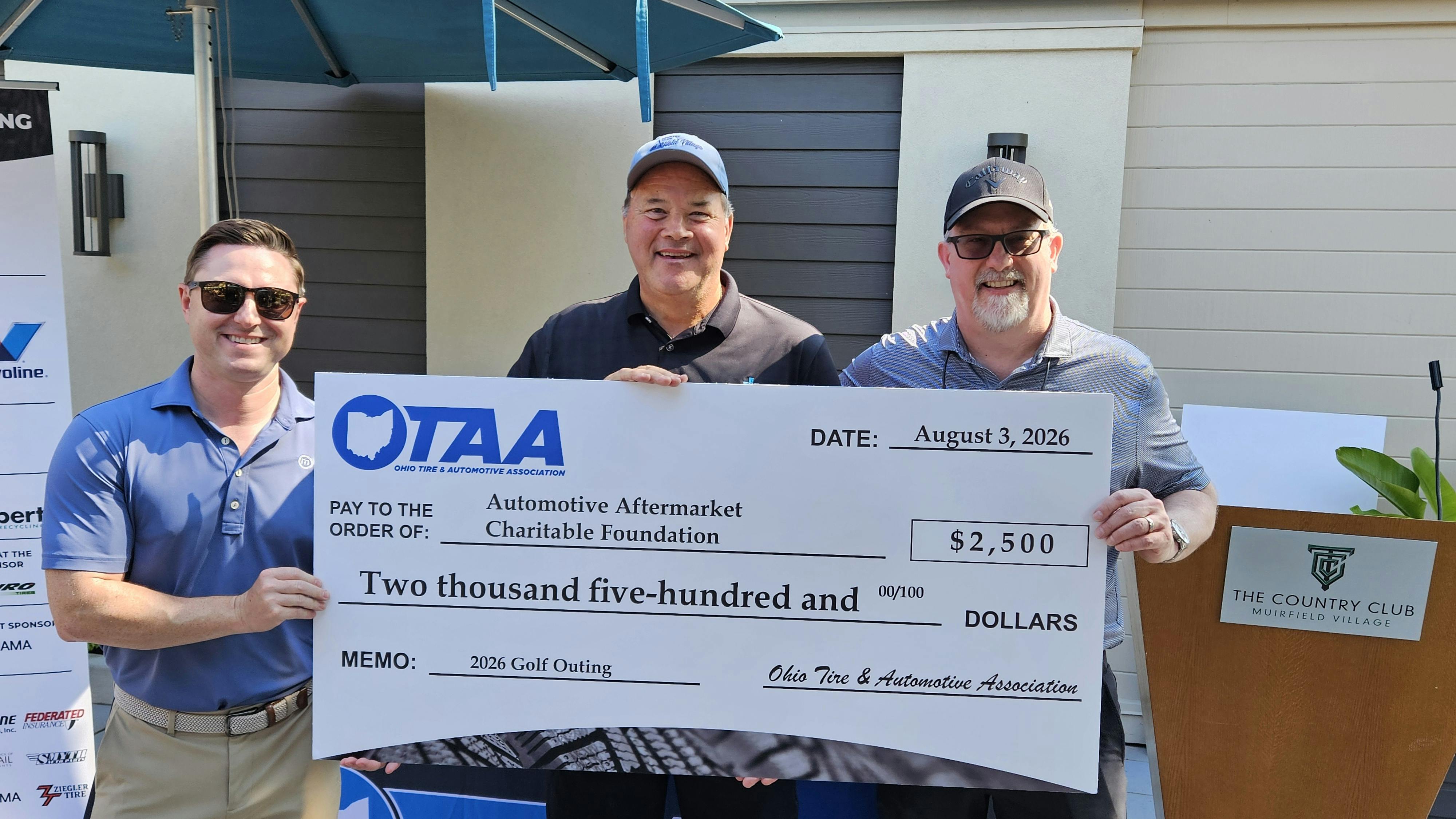 Jamie Ward, current OTAA president and president/CEO of Tire Discounters Inc. (right), and Alex Boehnke, executive director of the OTAA (left), present a donation to John Kairys (center), executive director of the AACF.