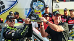 Ricky Benton II, vice president of Black's Tire, presents the Black’s Tire 250 NASCAR Craftsman Truck Series trophy to Corey Heim at Rockingham Speedway last April.